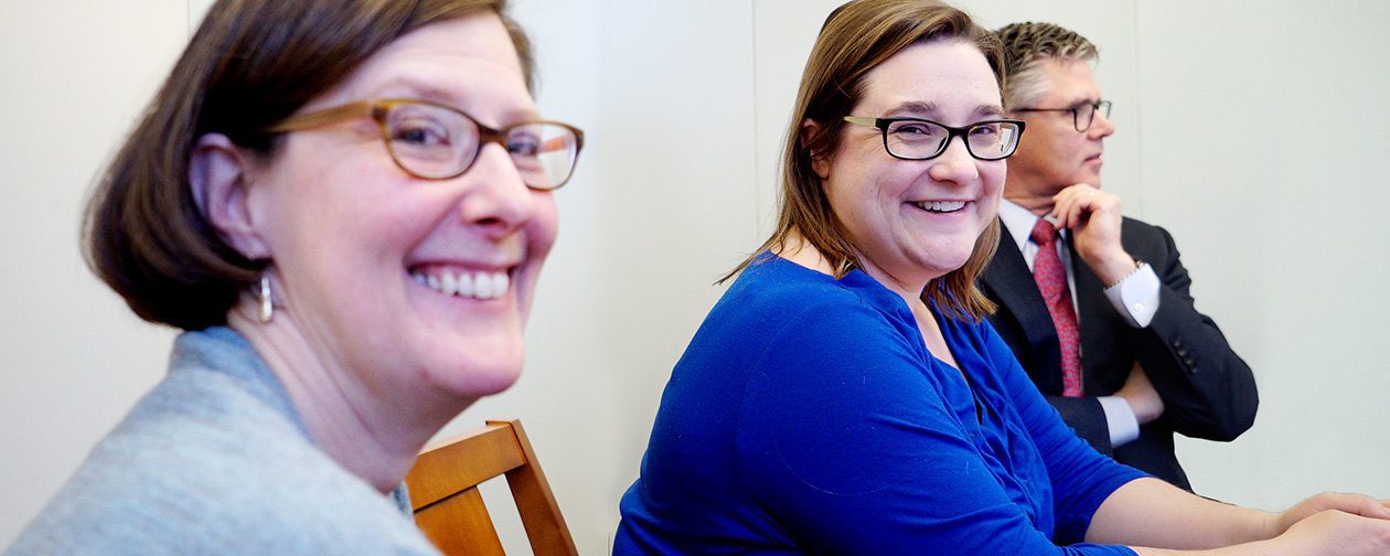 Portrait of two senior female partners at Bridgewater Advisors smiling during a collaborative meeting.