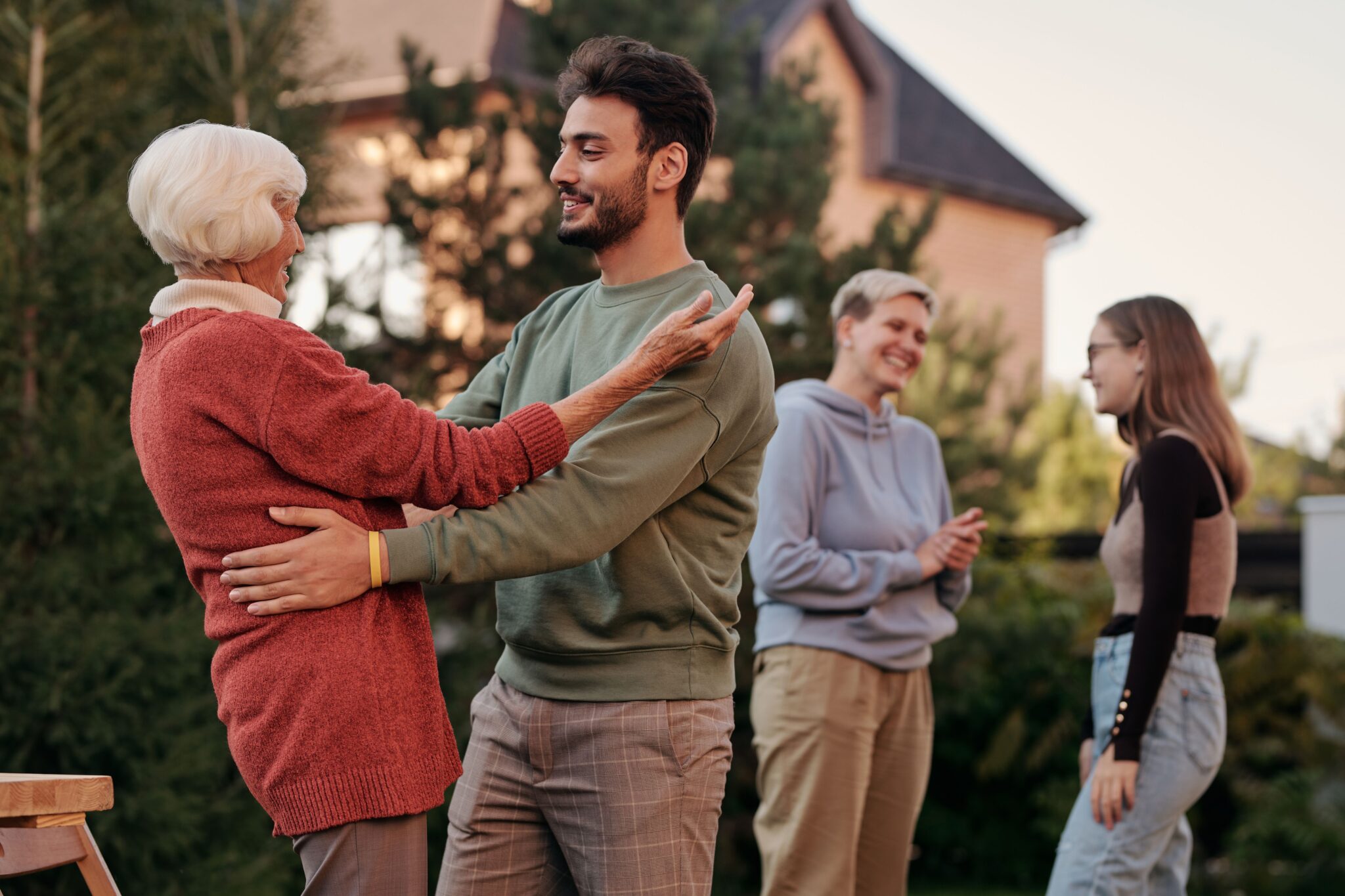Multi-generational family members hugging outside near a home, symbolizing strong family values and structured inheritance planning