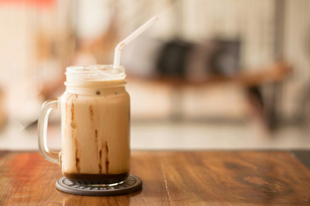 glass mug of ice coffee with a straw